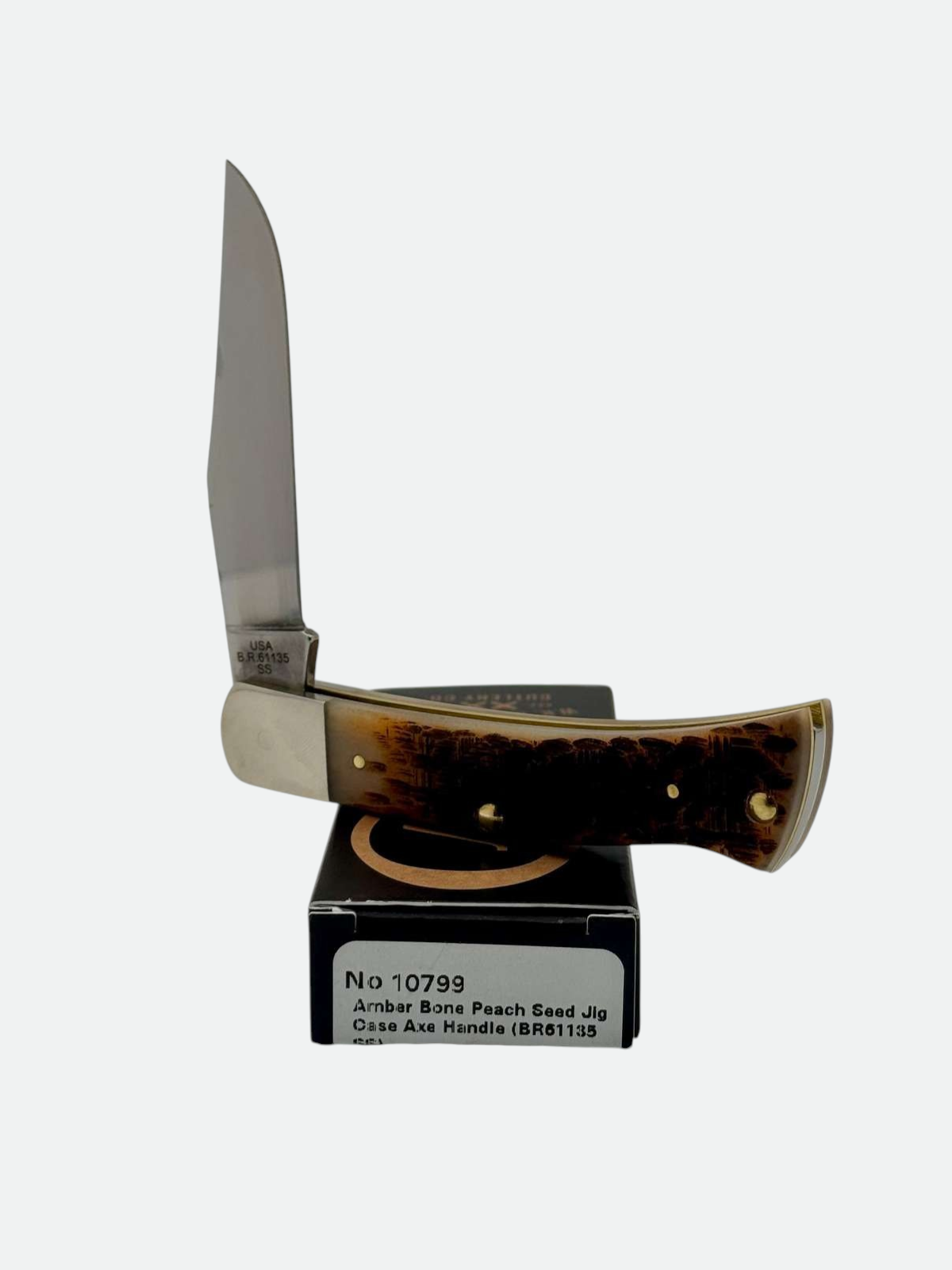 Pigeon Roost Knives Case XX Axe Handle pocket knife with amber bone peach seed jig scales and a clip point blade.