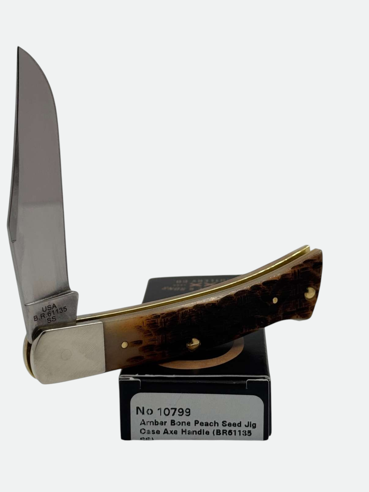 Pigeon Roost Knives Case XX Axe Handle pocket knife with amber bone peach seed jig scales and a clip point blade.