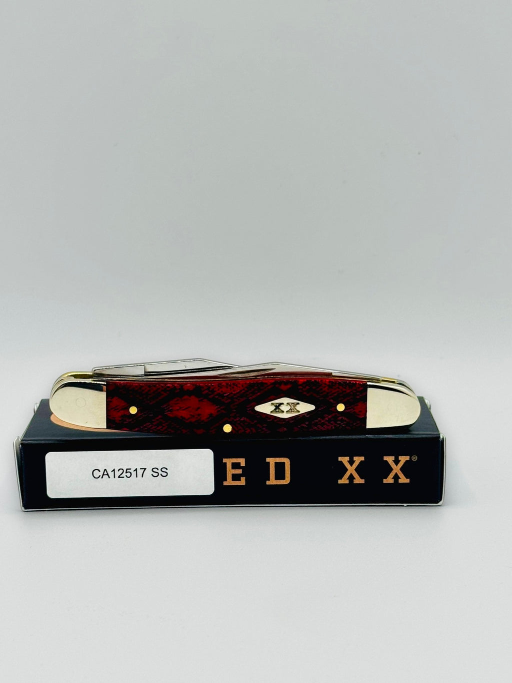 Case XX 12517SS Muskrat Snake Skin Red Bone — closed showing diamond shield