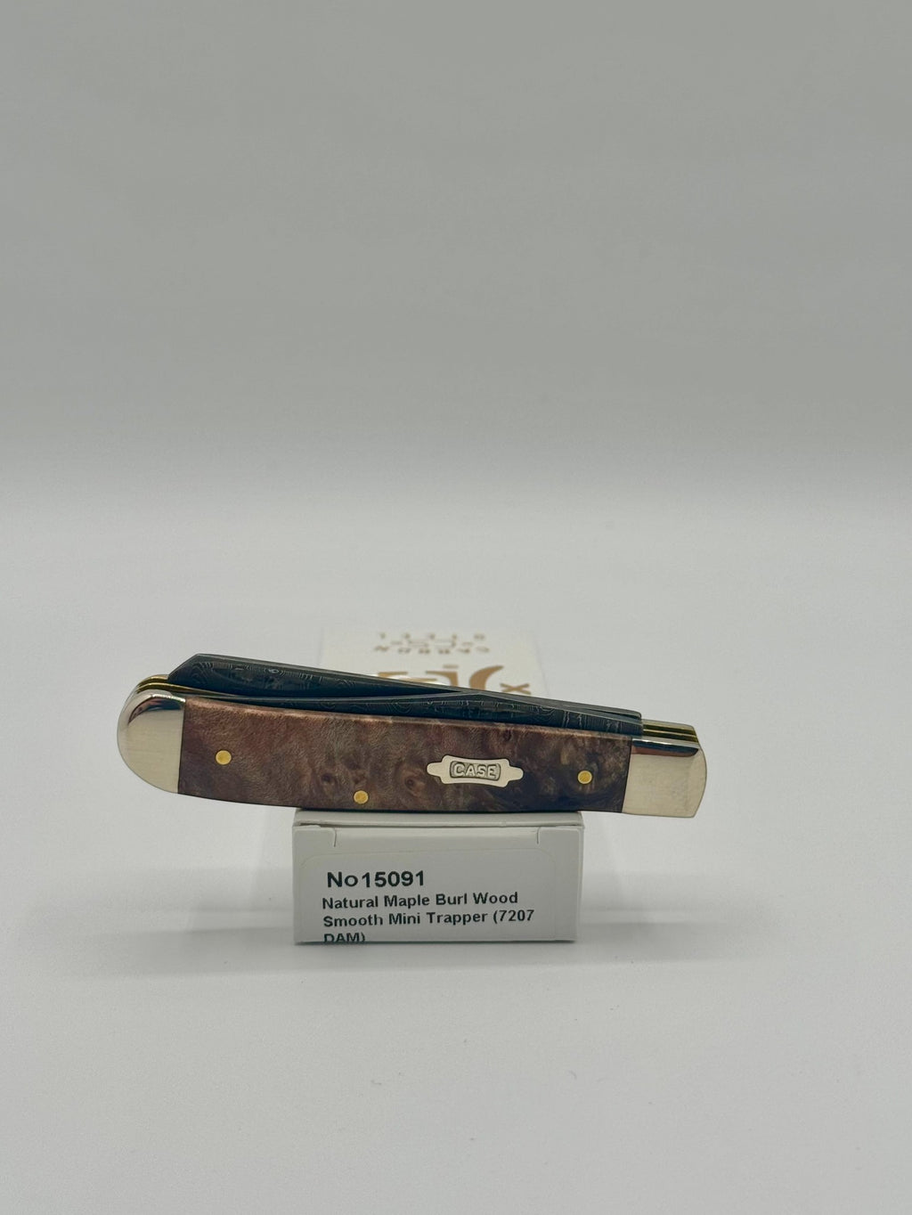 Case XX 15091 Natural Maple Burl Wood Ladder Damascus Mini Trapper — lifestyle angle on Case box