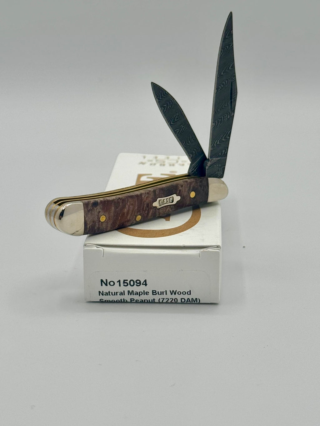 Case XX 15094 Smooth Natural Maple Burl Wood Damascus Peanut — blade detail on Case box