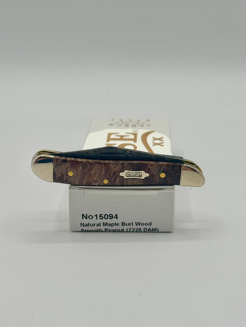 Case XX 15094 Smooth Natural Maple Burl Wood Damascus Peanut — lifestyle angle on Case box
