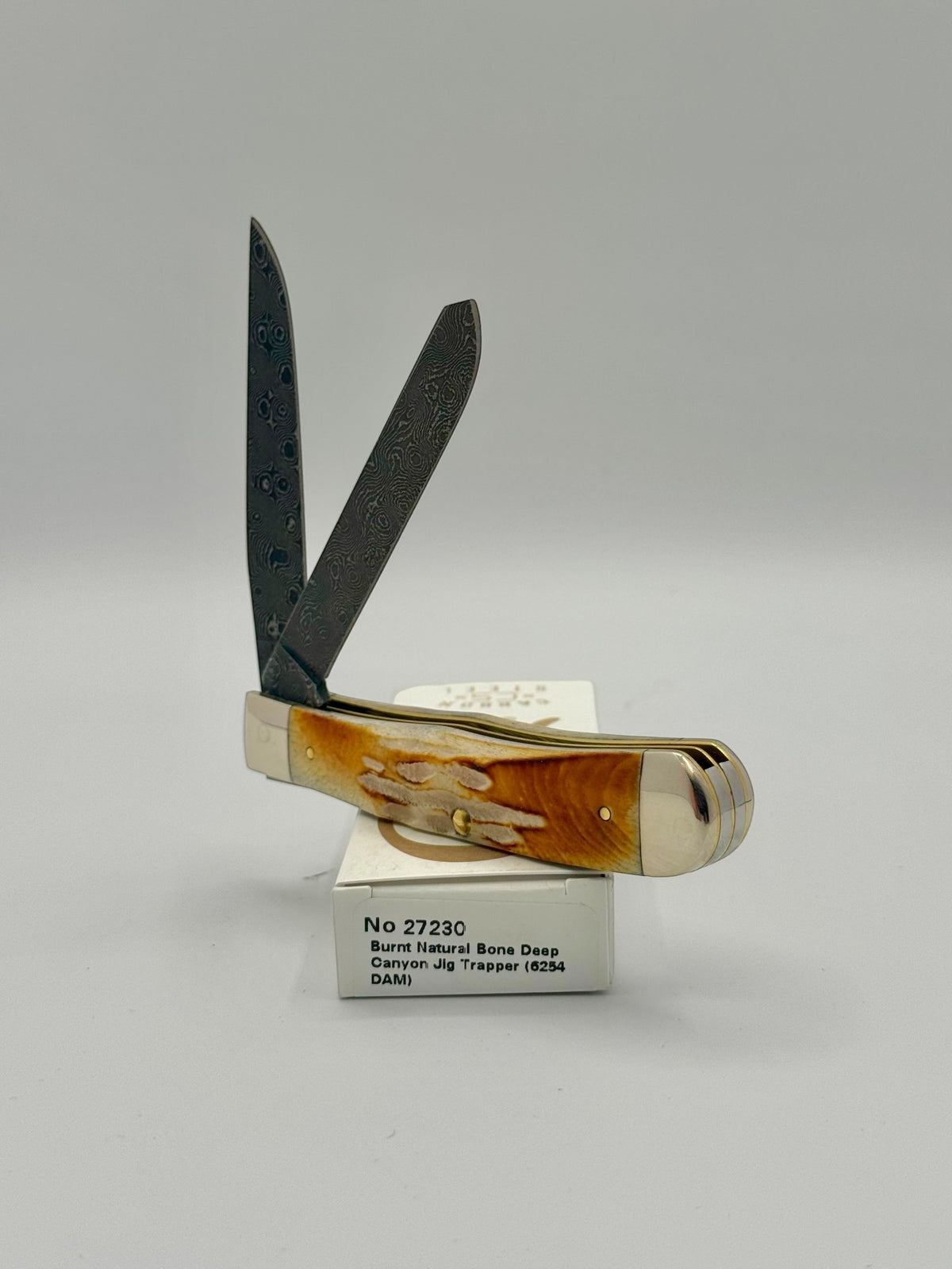 Case XX 27230 Damascus Burnt Natural Bone Deep Canyon Jig Trapper — handle and shield detail