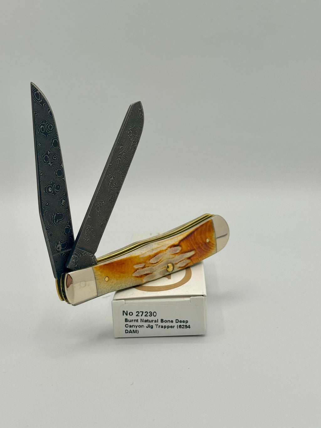 Case XX 27230 Damascus Burnt Natural Bone Deep Canyon Jig Trapper — back side on Case box