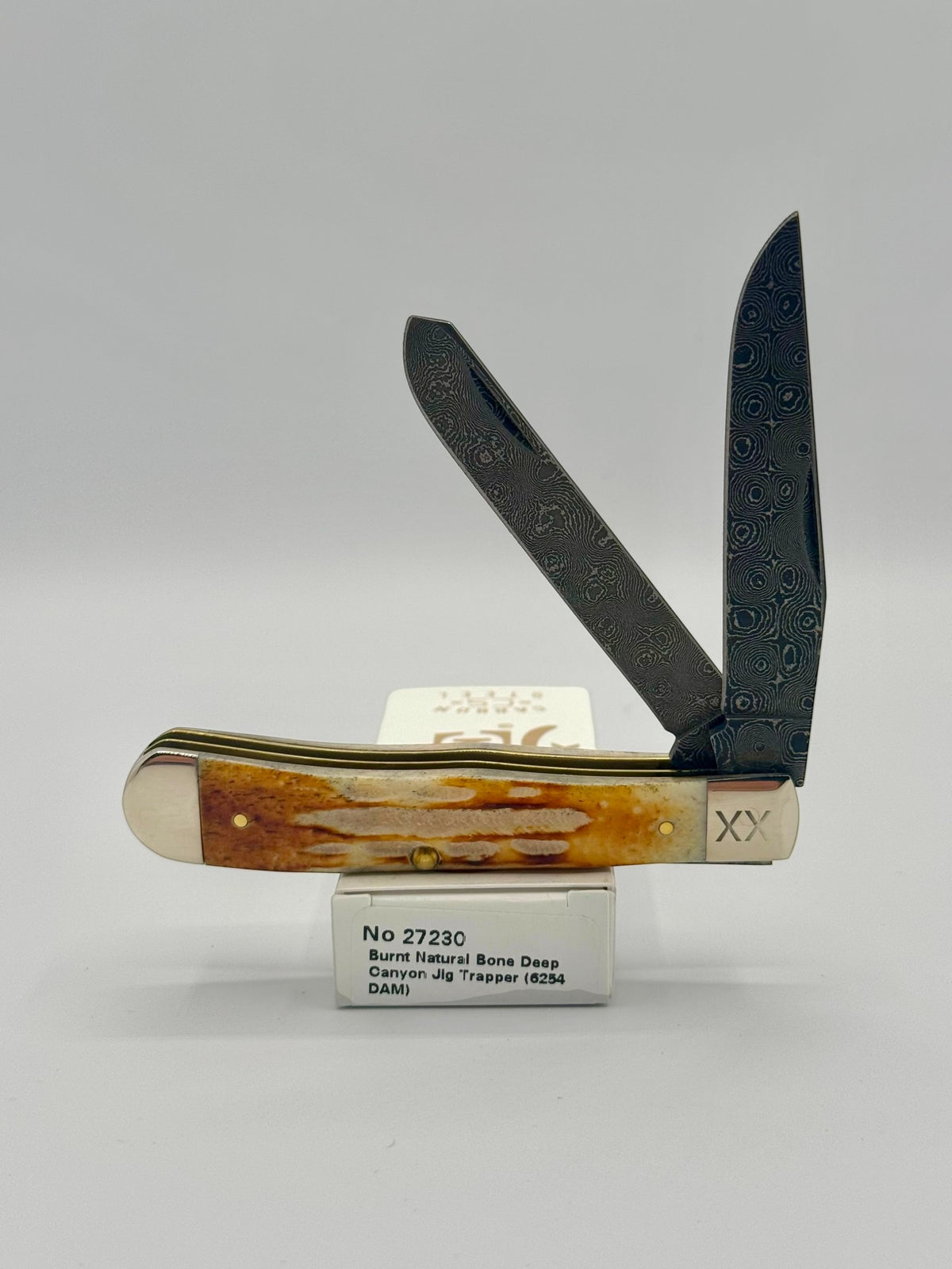 Case XX 27230 Damascus Burnt Natural Bone Deep Canyon Jig Trapper — open on Case retail box