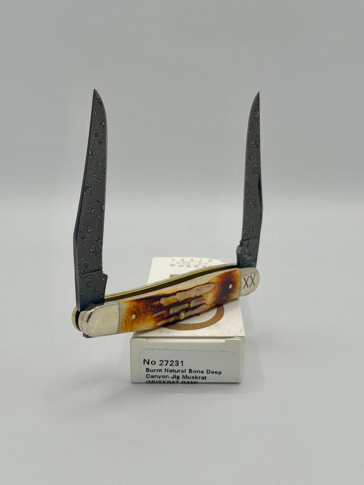 Case XX 27231 Damascus Burnt Natural Bone Deep Canyon Jig Muskrat — blade detail on Case box