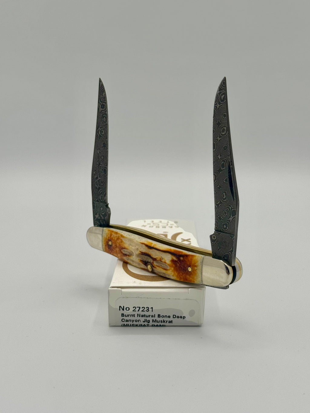 Case XX 27231 Damascus Burnt Natural Bone Deep Canyon Jig Muskrat — handle and shield detail