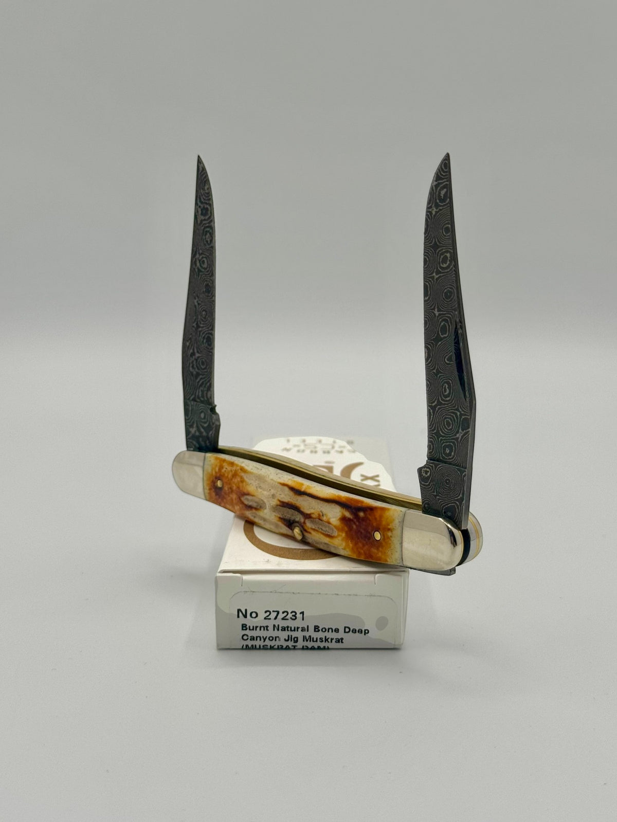 Case XX 27231 Damascus Burnt Natural Bone Deep Canyon Jig Muskrat — handle and shield detail