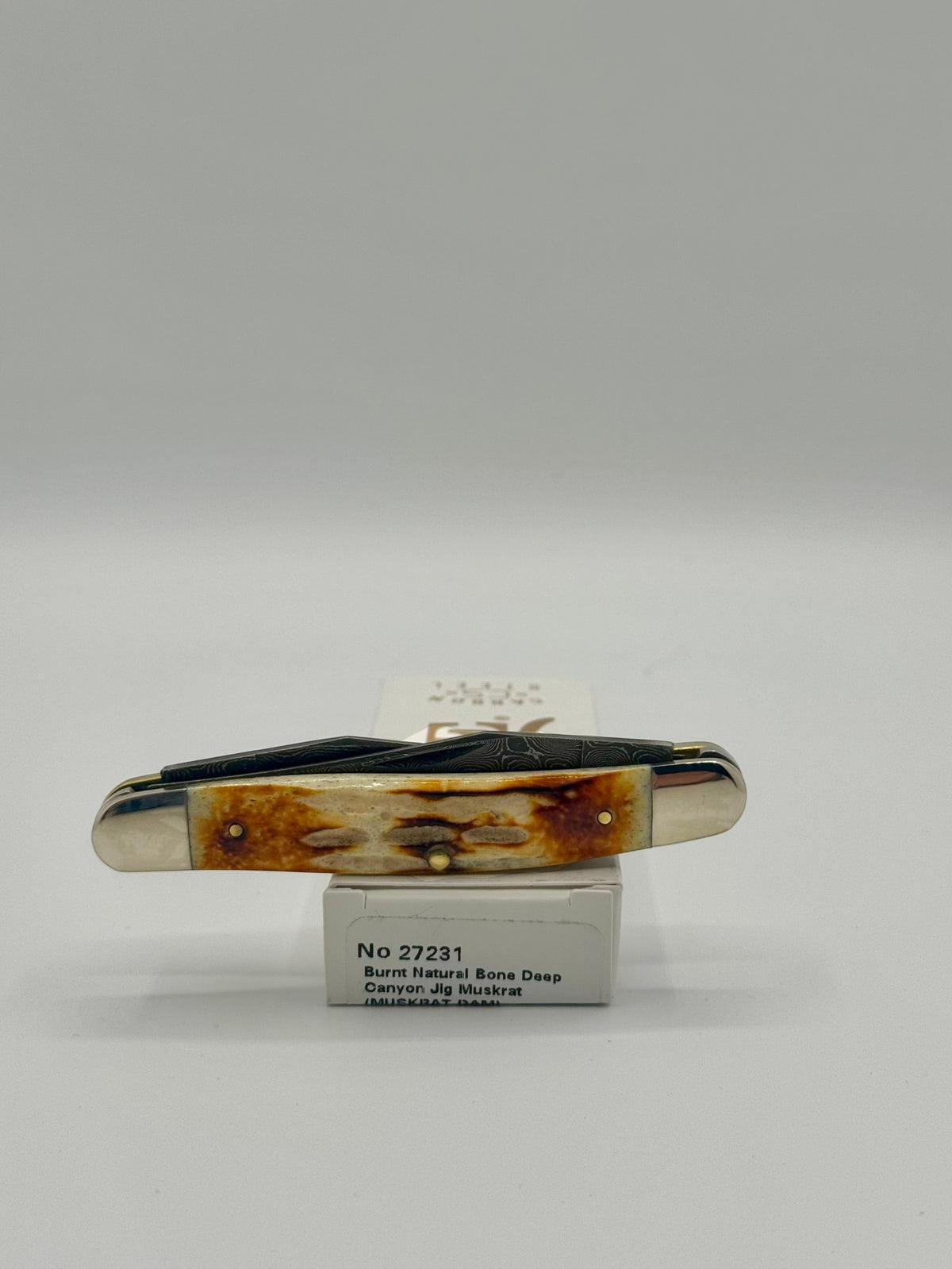 Case XX 27231 Damascus Burnt Natural Bone Deep Canyon Jig Muskrat — packaging and knife together