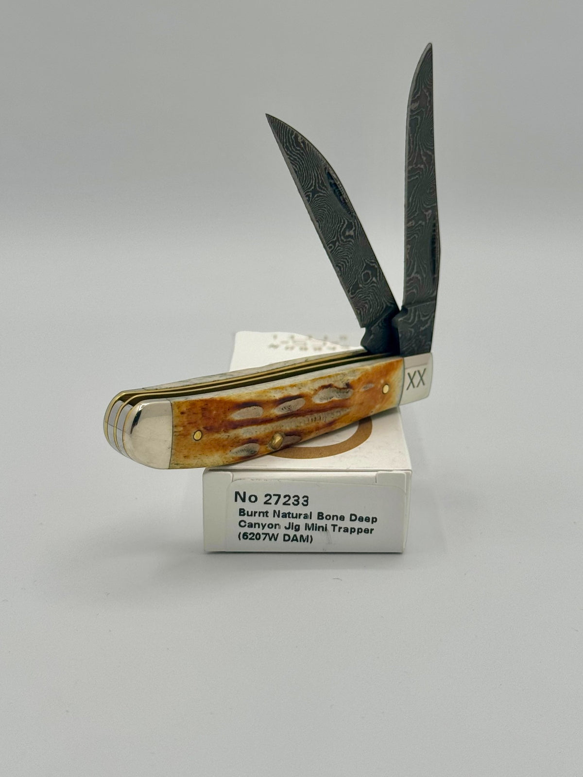 Case XX 27233 Damascus Burnt Natural Bone Deep Canyon Jig Mini Trapper — blade detail on Case box