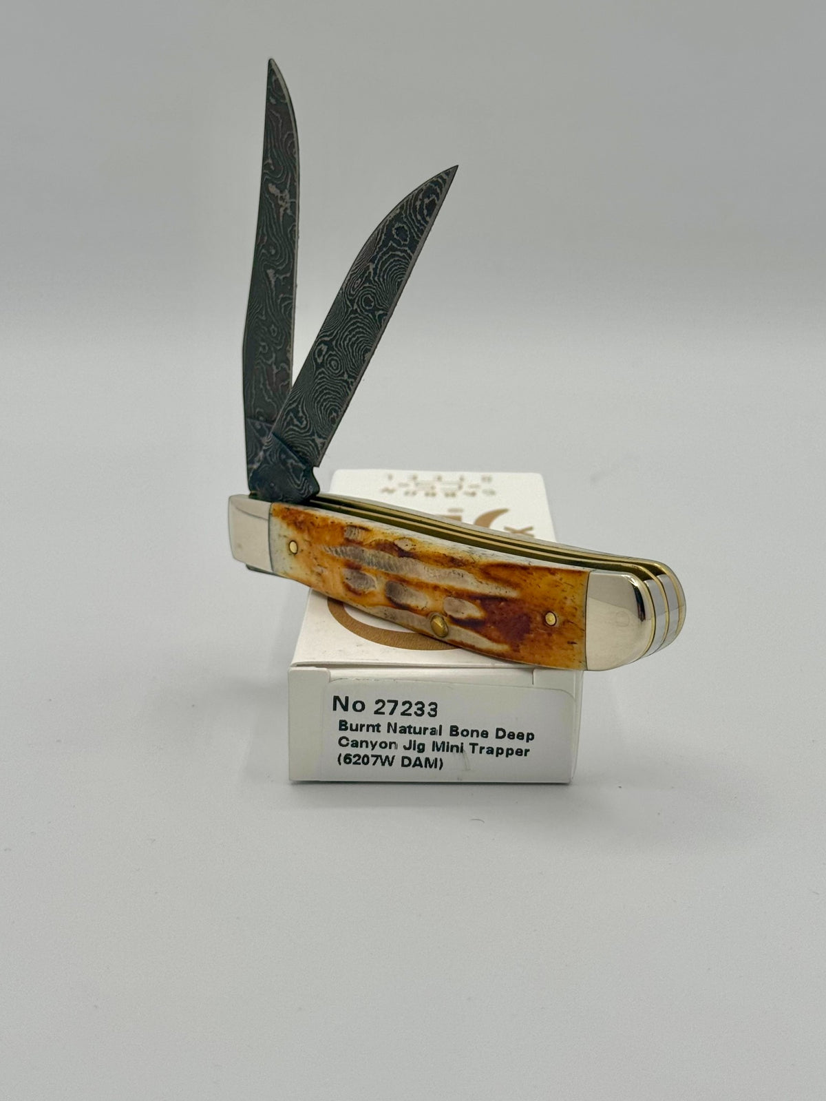 Case XX 27233 Damascus Burnt Natural Bone Deep Canyon Jig Mini Trapper — handle and shield detail