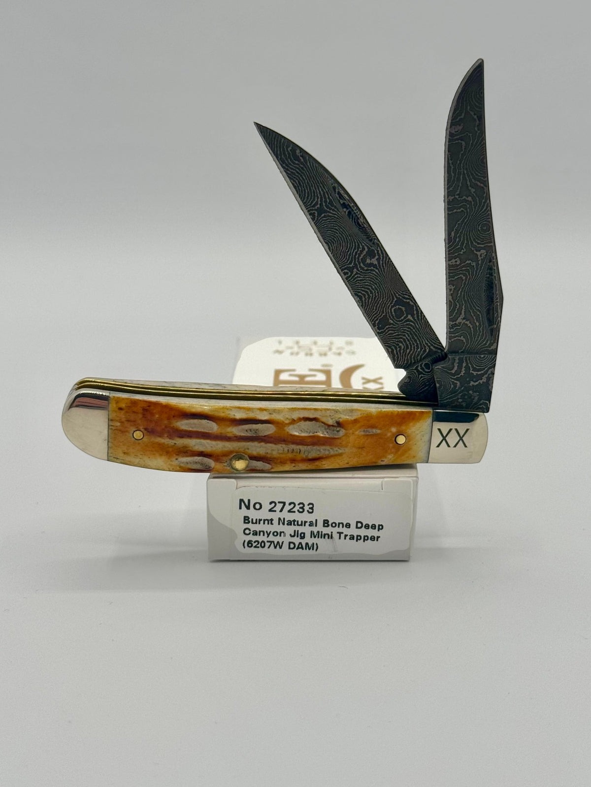 Case XX 27233 Damascus Burnt Natural Bone Deep Canyon Jig Mini Trapper — open on Case retail box