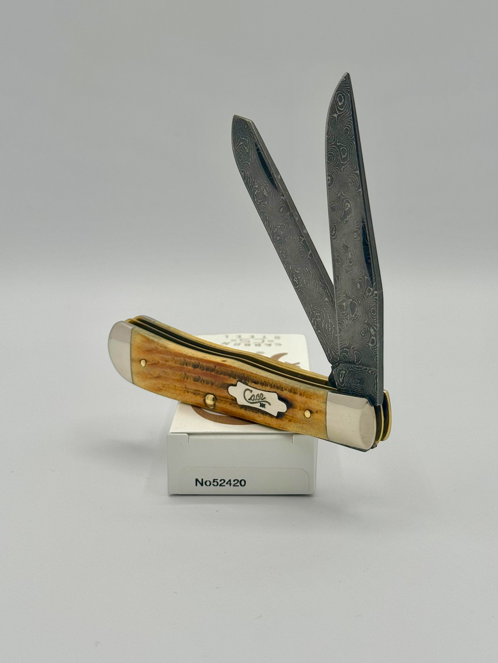 Case XX 52420 Burnt Goldenrod Second Cut Damascus Trapper — closed on Case box