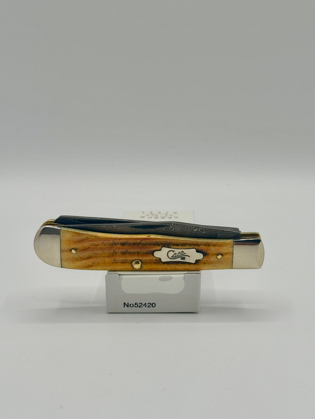 Case XX 52420 Burnt Goldenrod Second Cut Damascus Trapper — lifestyle angle on Case box