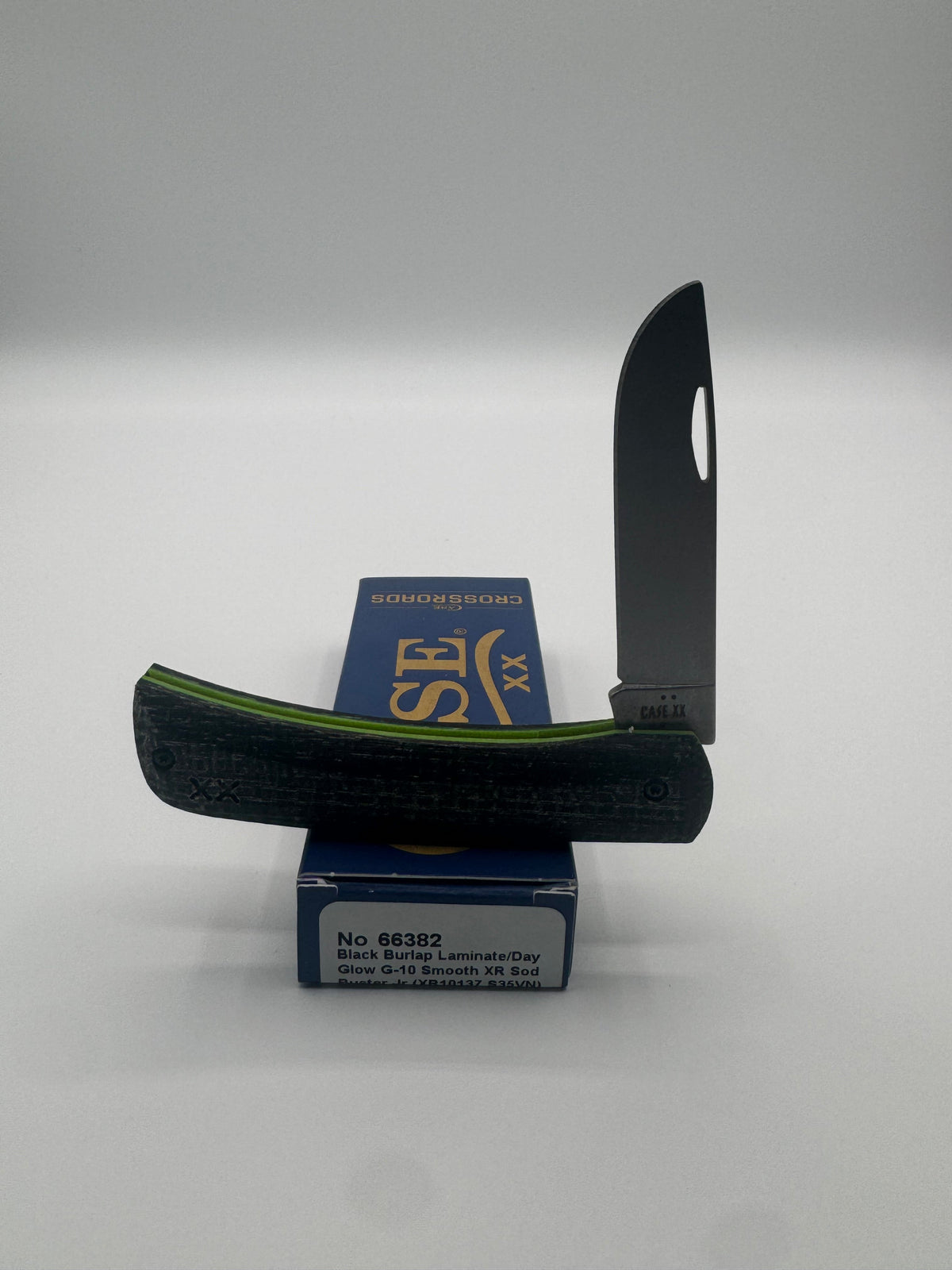 Pigeon Roost Knives Case XX Sod Buster Jr with black burlap laminate handle, neon green G-10 liners, and steel blade.