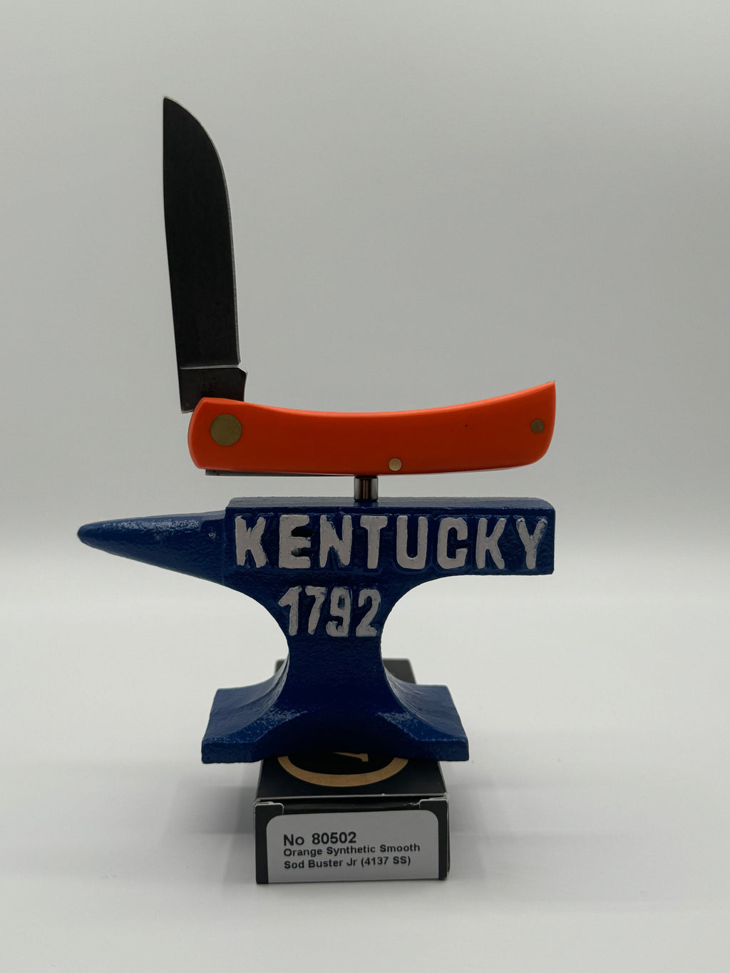 Pigeon Roost Knives Case XX Sod Buster Jr pocket knife with a bright orange synthetic handle balanced on an anvil