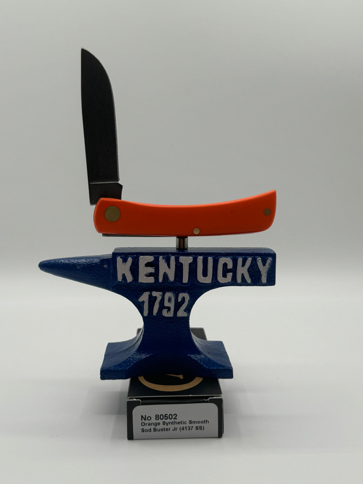 Pigeon Roost Knives Case XX Sod Buster Jr pocket knife with a bright orange synthetic handle balanced on an anvil