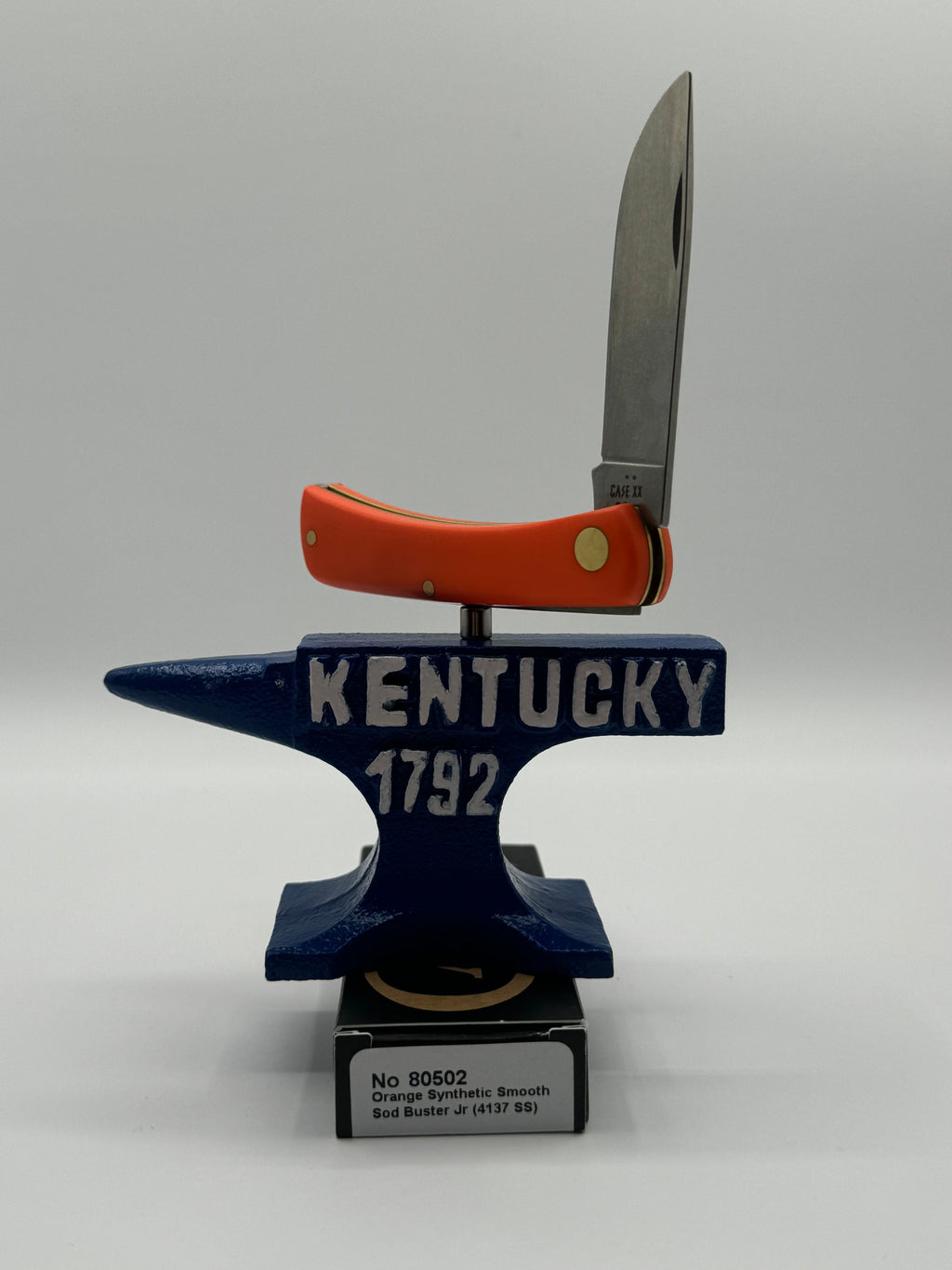 Pigeon Roost Knives Case XX Sod Buster Jr pocket knife with a smooth orange synthetic handle on a Kentucky anvil stand