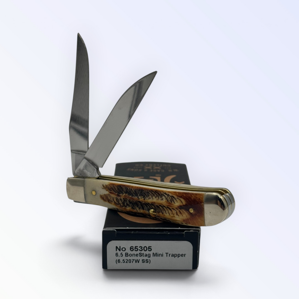 Catalog 65305 Case XX – 6.5 BoneStag Mini Trapper — open blades resting on factory packaging