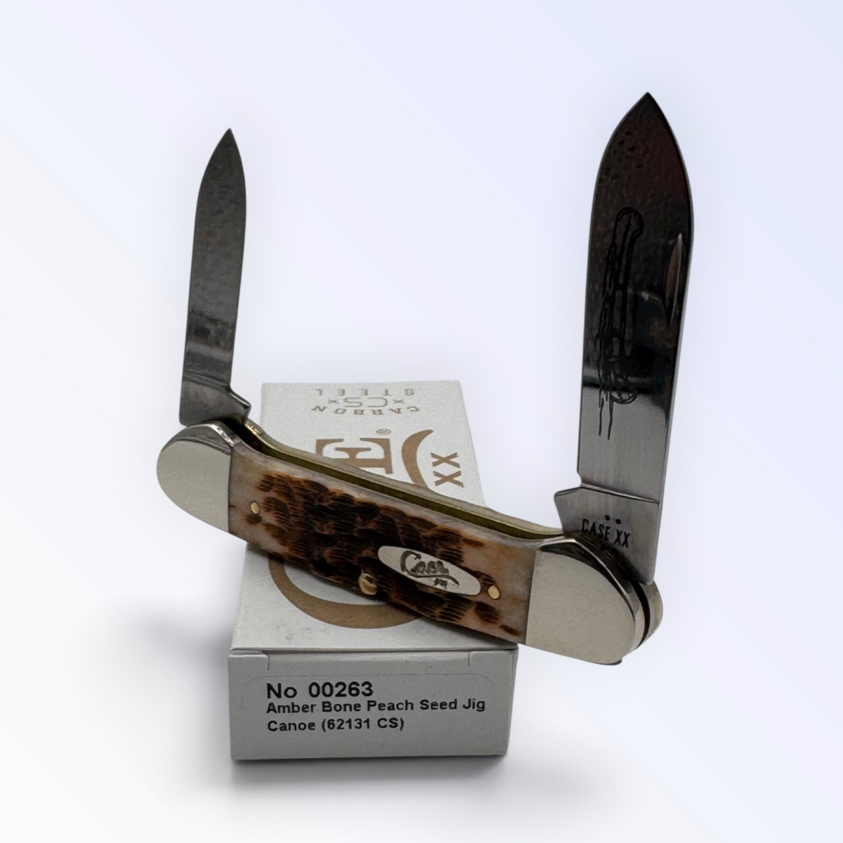 Pigeon Roost Knives Case XX Canoe pocket knife with amber bone peach seed jigged handle and dual carbon steel blades.