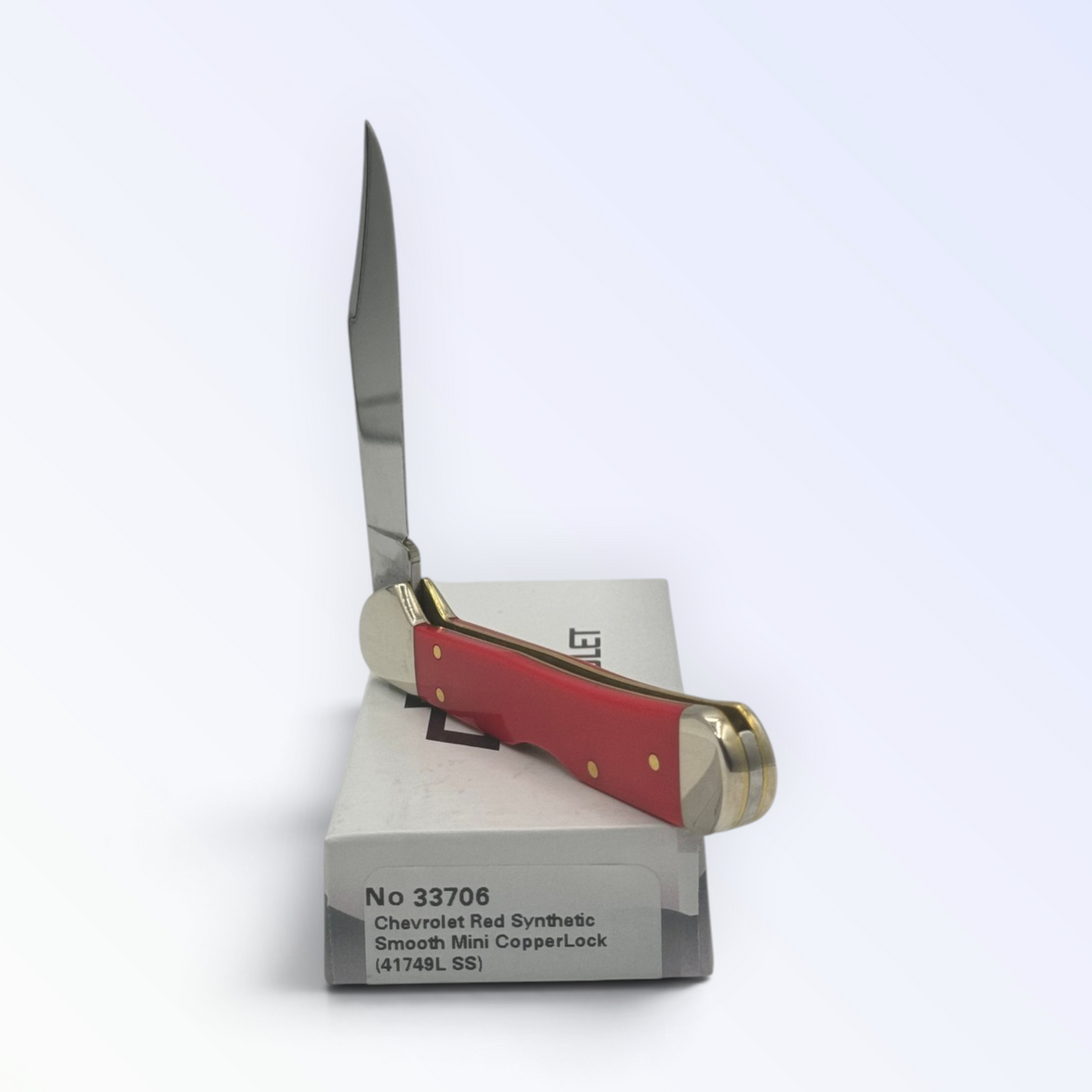 Catalog 33706 Case XX Chevrolet Red Synthetic Mini Copperlock — open blades resting on factory packaging