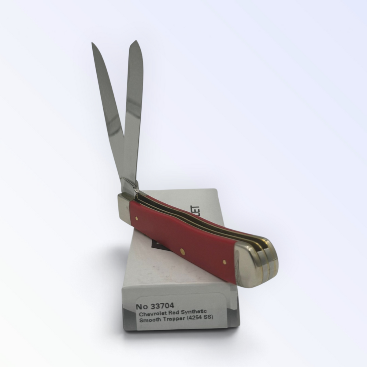 Catalog 33704 Case XX Chevrolet Red Synthetic Trapper — open blades resting on factory packaging