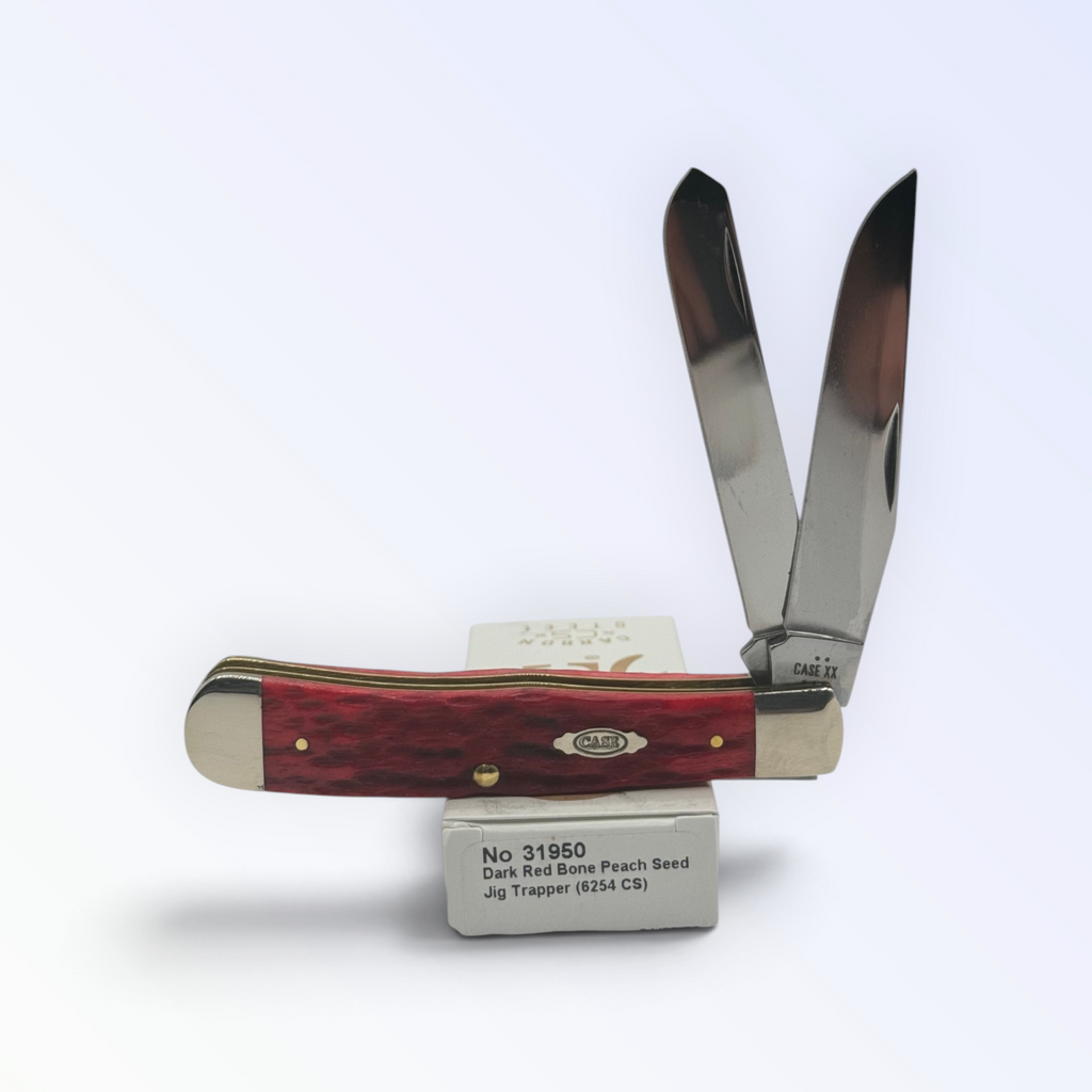 Case XX – Dark Red Bone Peach Seed Jig Trapper with SKU 31950 — blades open resting on the factory box