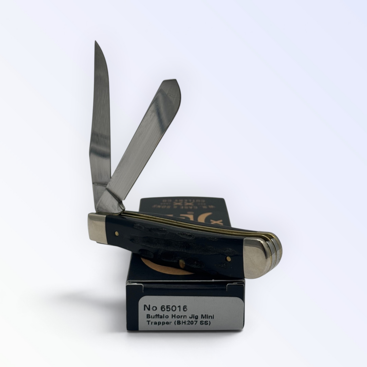 Catalog 65016 Case XX Jigged Genuine Buffalo Horn Mini Trapper — open blades resting on factory packaging