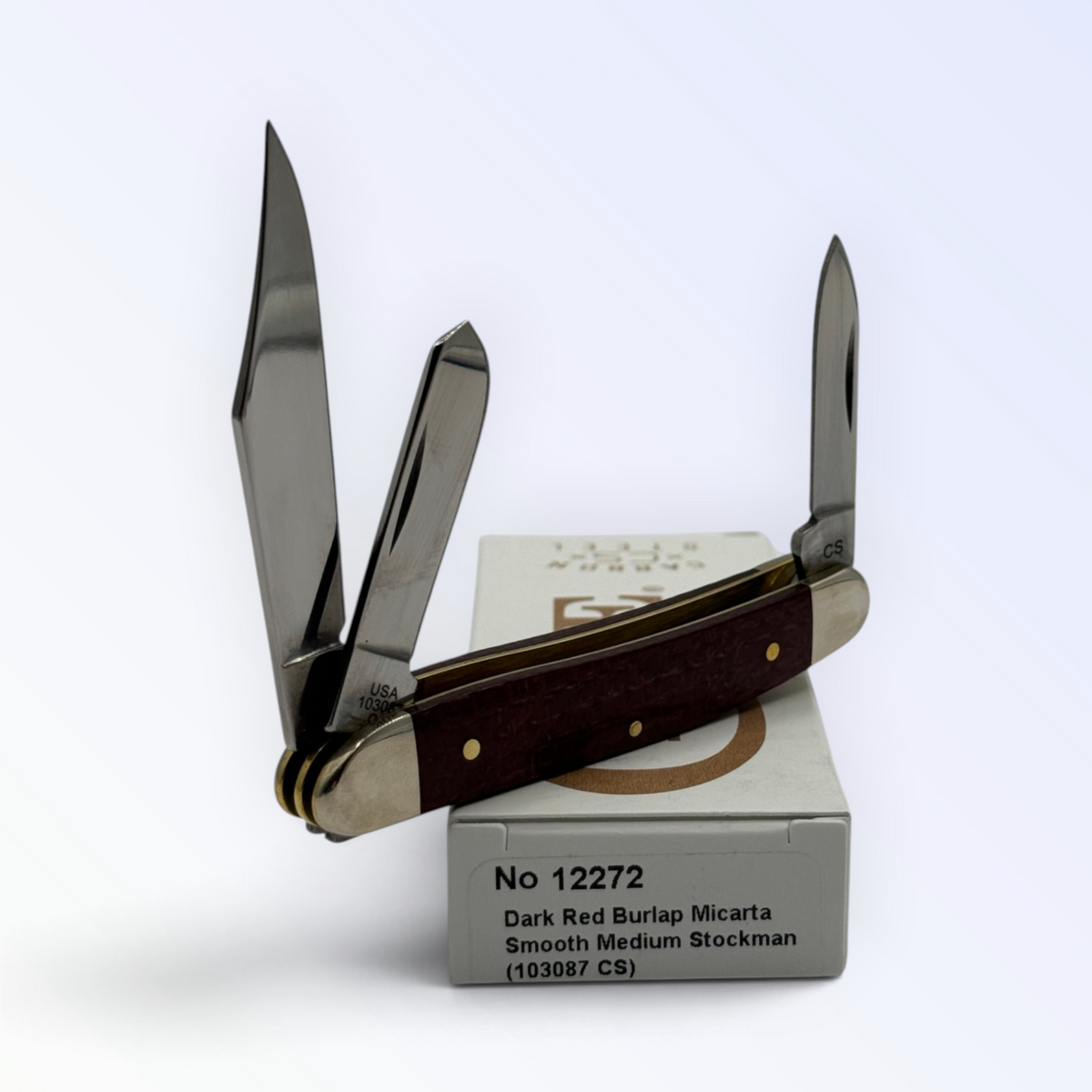 Catalog 12272 Case XX Medium Stockman — dark red burlap Micarta, close view of handle texture with blades open on box