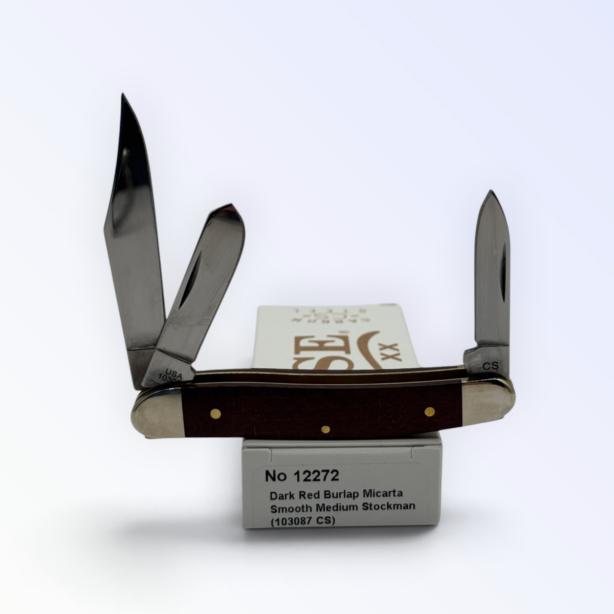 Case XX Medium Stockman (12272) featuring dark red burlap Micarta; studio shot open atop the retail box