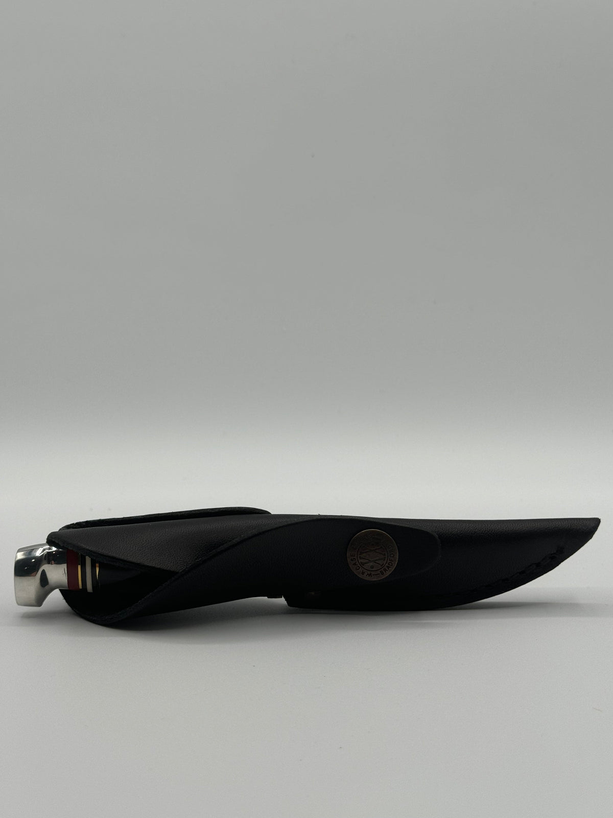 Pigeon Roost Knives Case XX Mini Finn fixed blade knife inside a black leather sheath with a branded metal snap