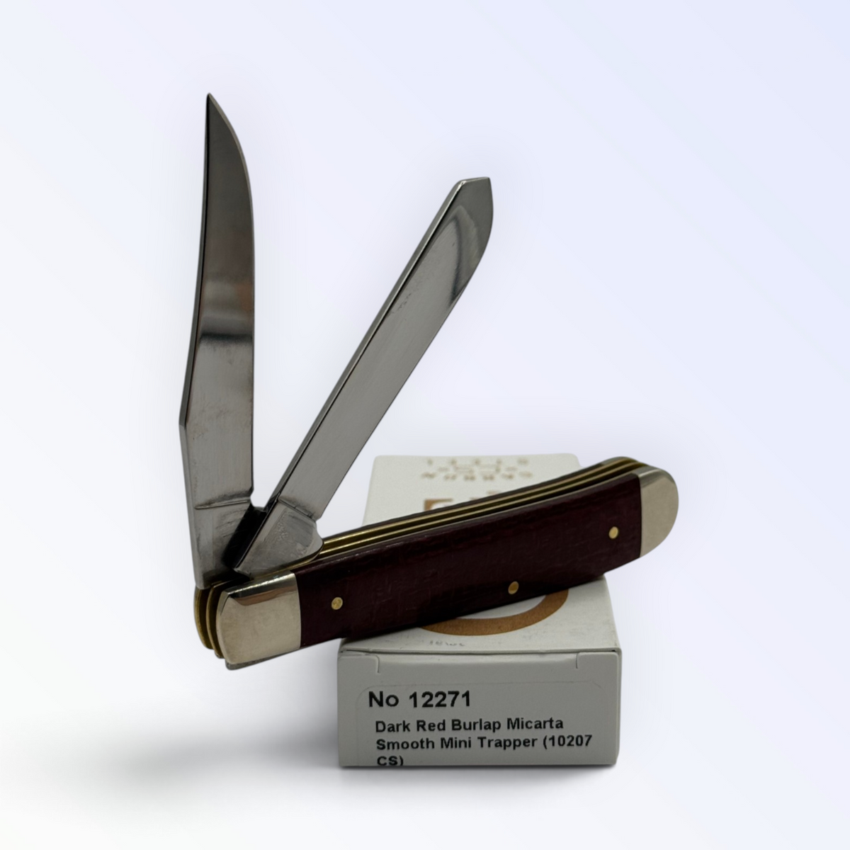 Catalog 12271 Case XX Mini Trapper — dark red burlap Micarta, close view of handle texture with blades open on box