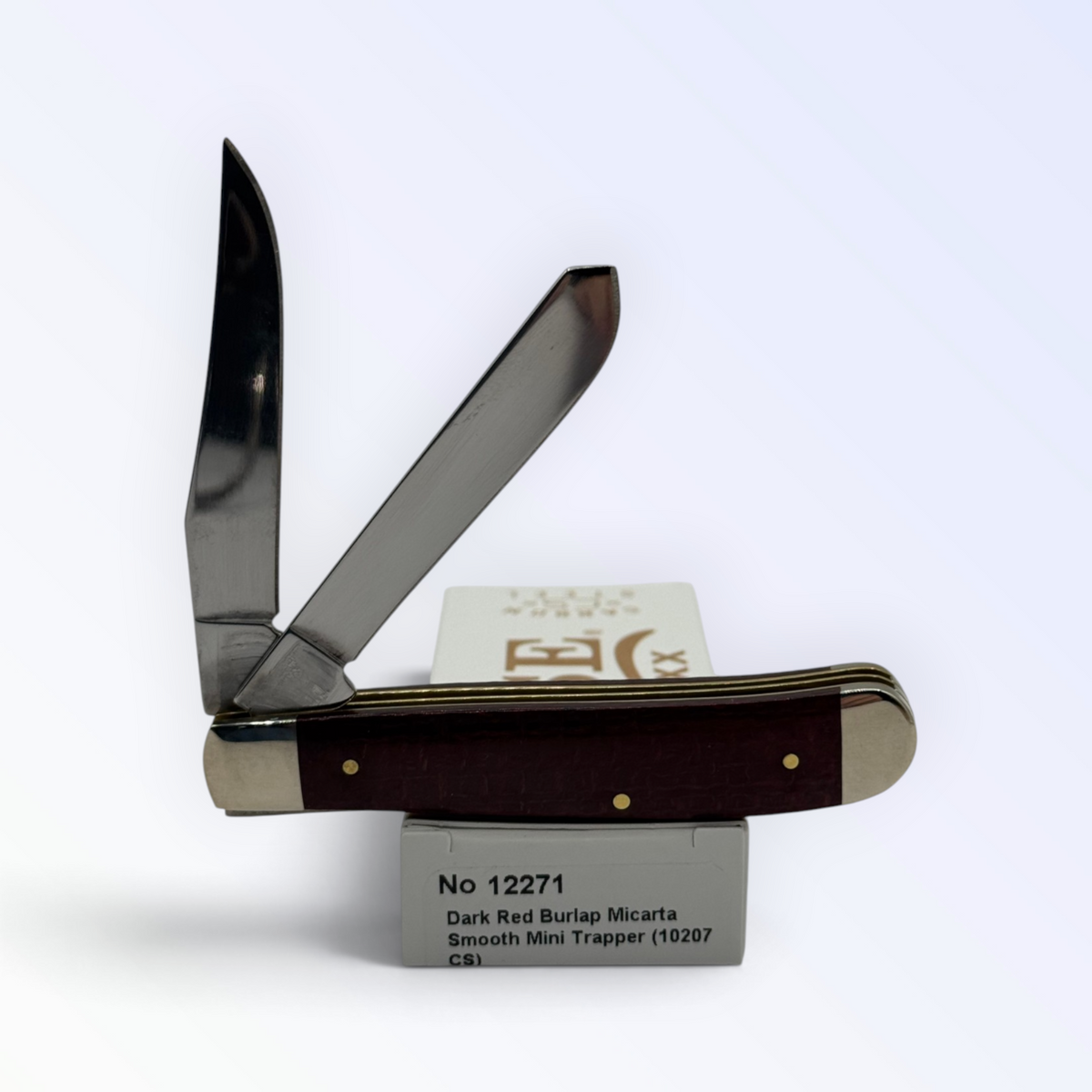 Case XX Mini Trapper (12271) featuring dark red burlap Micarta; studio shot open atop the retail box