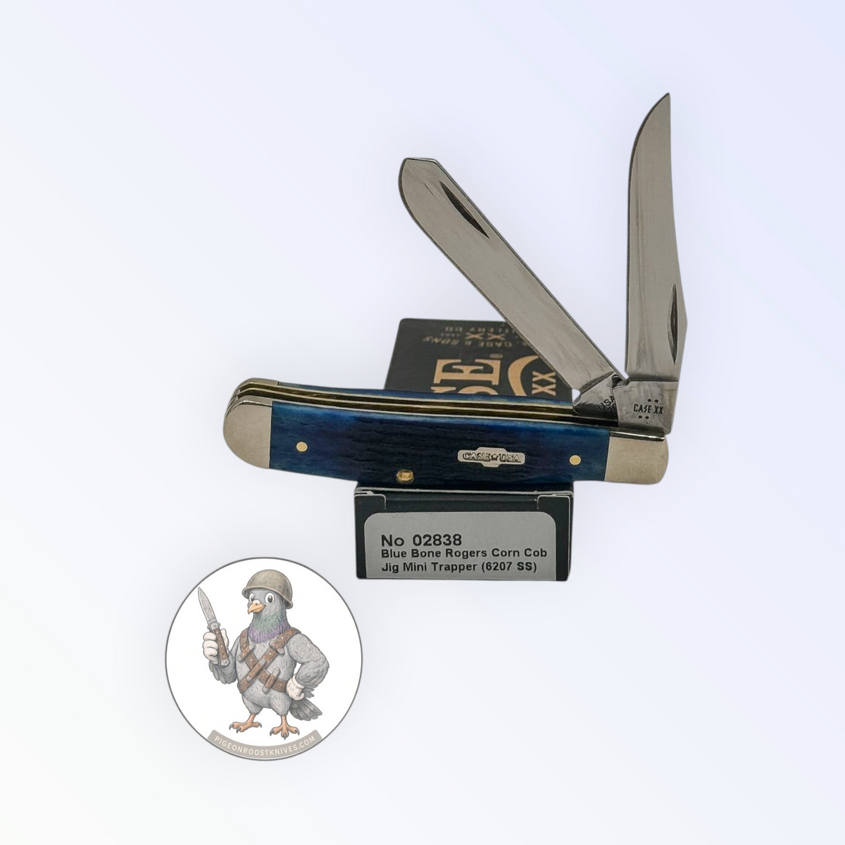 Case XX Mini Trapper with jigged navy blue bone and clip and spey blades, SKU 02838 — blades open resting on the factory box
