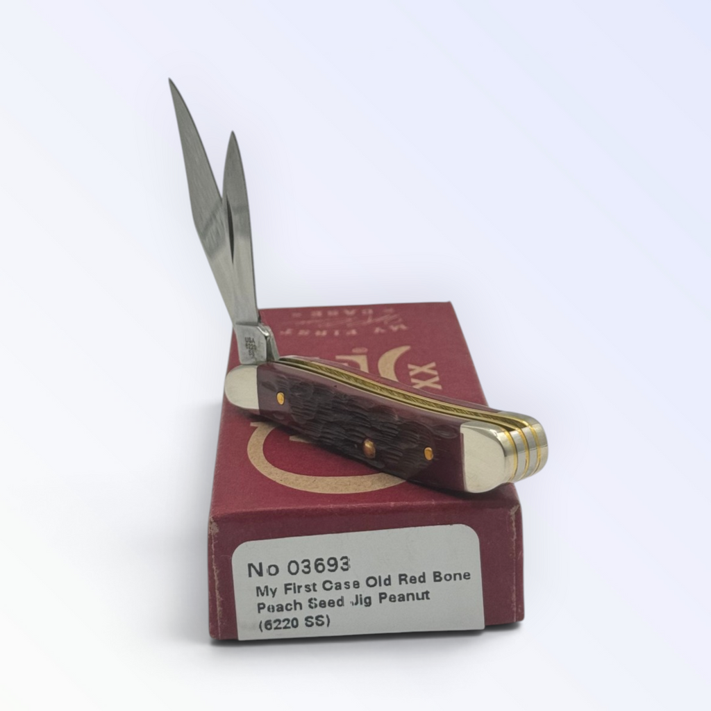 Catalog 03693 Case XX My First Case Old Red Bone Peach Seed Jig Peanut — open blades resting on factory packaging