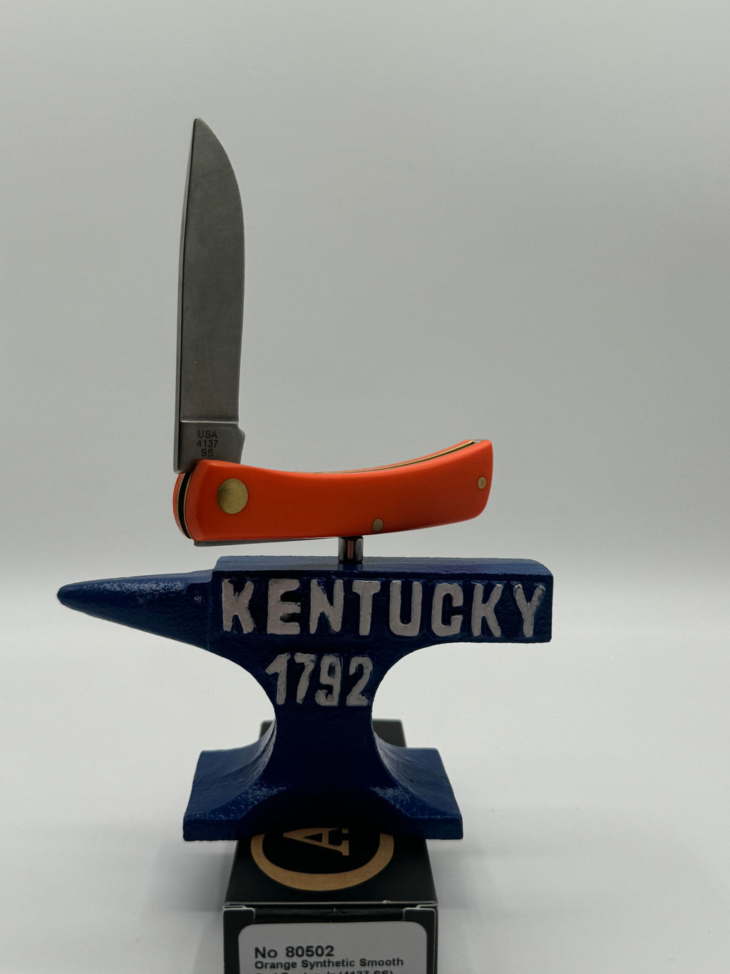 Pigeon Roost Knives Case XX Sod Buster Jr pocket knife with a smooth orange handle displayed on a Kentucky anvil
