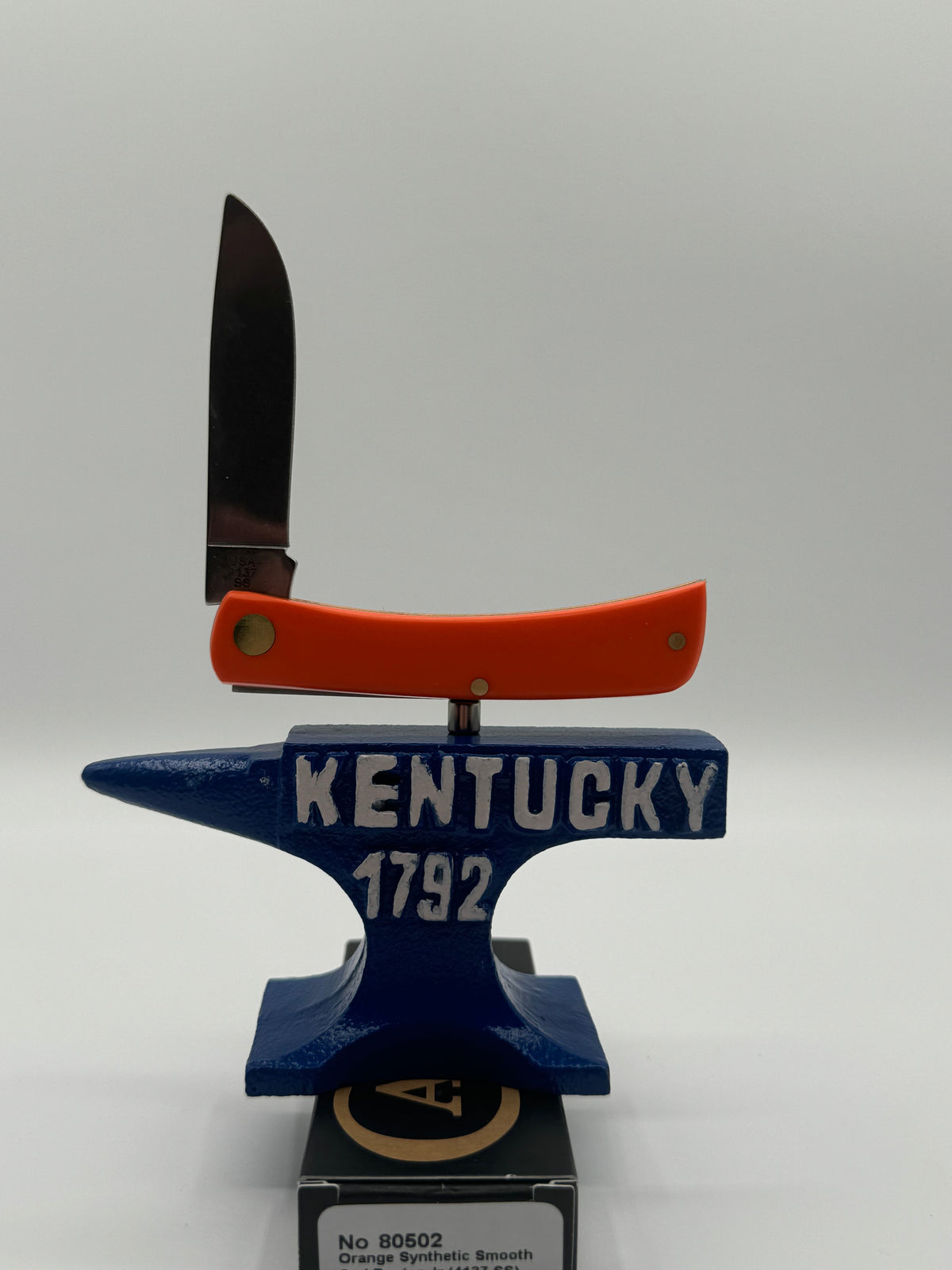 Pigeon Roost Knives Case XX Sod Buster Jr pocket knife with smooth orange handle and Aliens artwork on an anvil stand