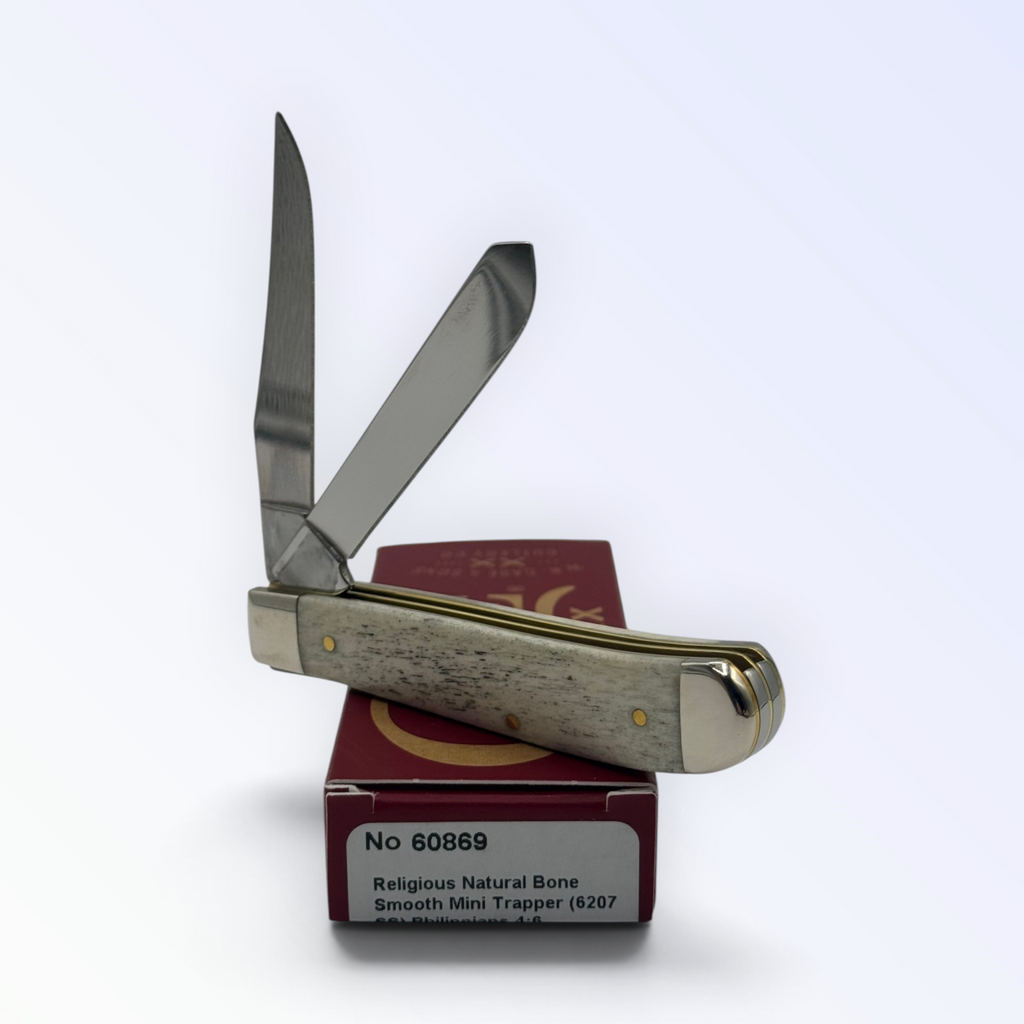 Catalog 60869 Case XX – Religious Natural Bone Smooth Mini Trapper (Philippians 4:6) — open blades resting on factory packaging
