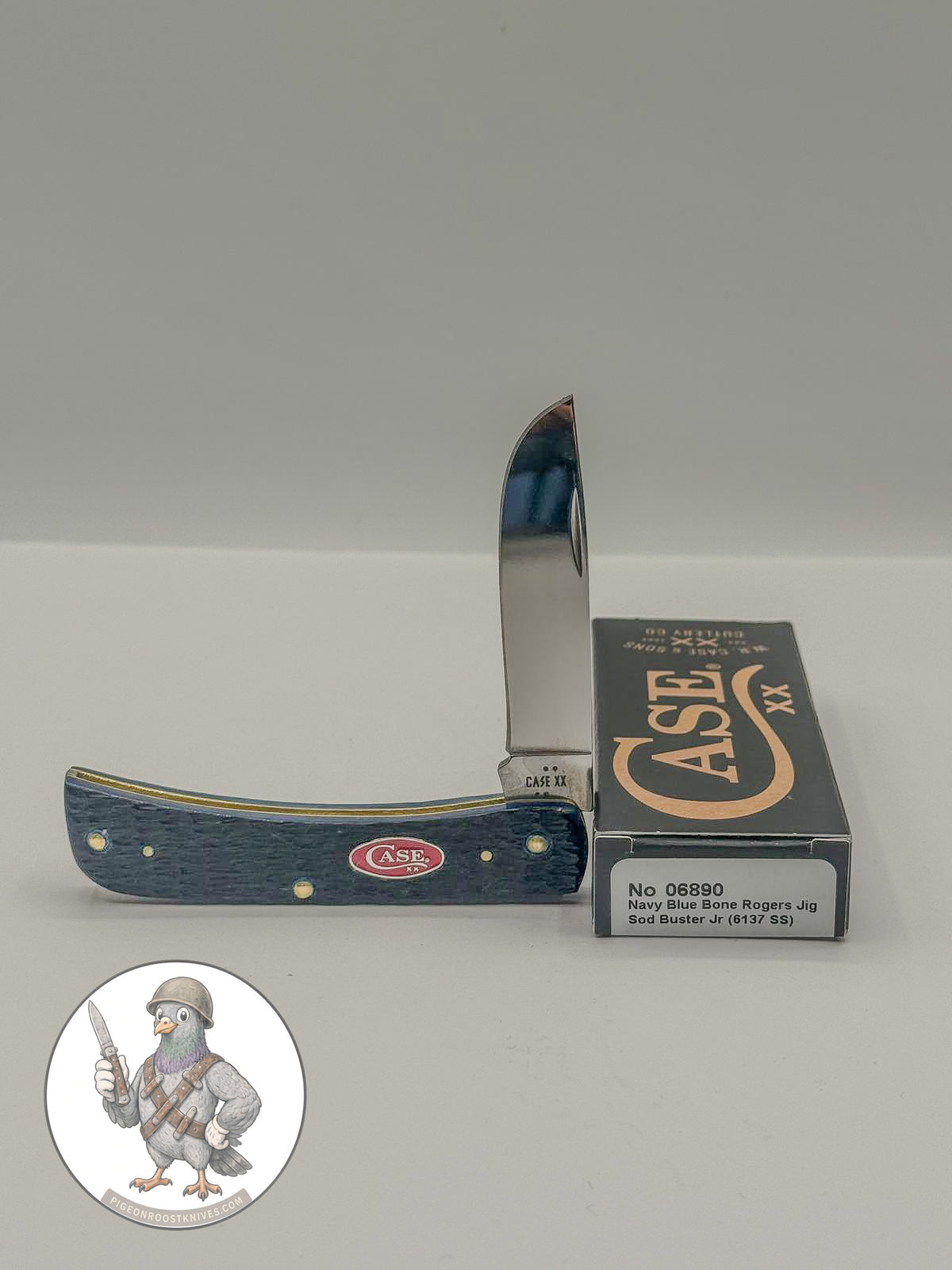 Case XX Rogers Jig Navy Blue Bone Sod Buster Jr with SKU 06890 — blades open resting on the factory box