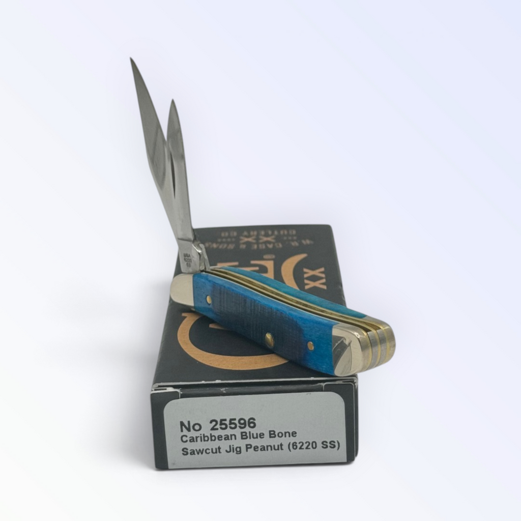 Catalog 25596 Case XX Sawcut Caribbean Blue Bone Peanut — open blades resting on factory packaging