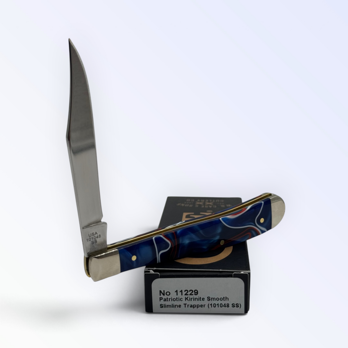 Catalog 11229 Case XX Slimline Trapper — Patriotic Kirinite, close view of handle texture with blades open on box