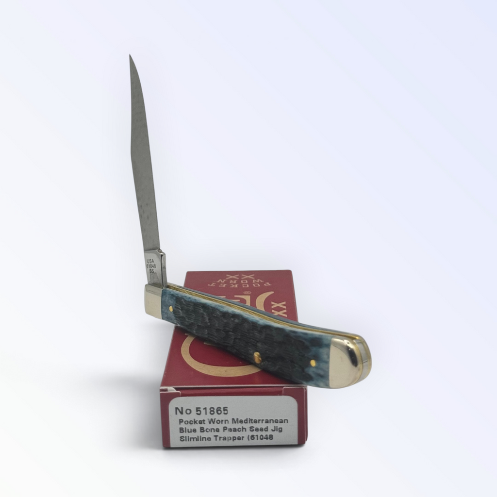 Catalog 51865 Case XX Slimline Trapper Peach Seed Mediterranean Blue Bone — open blades resting on factory packaging