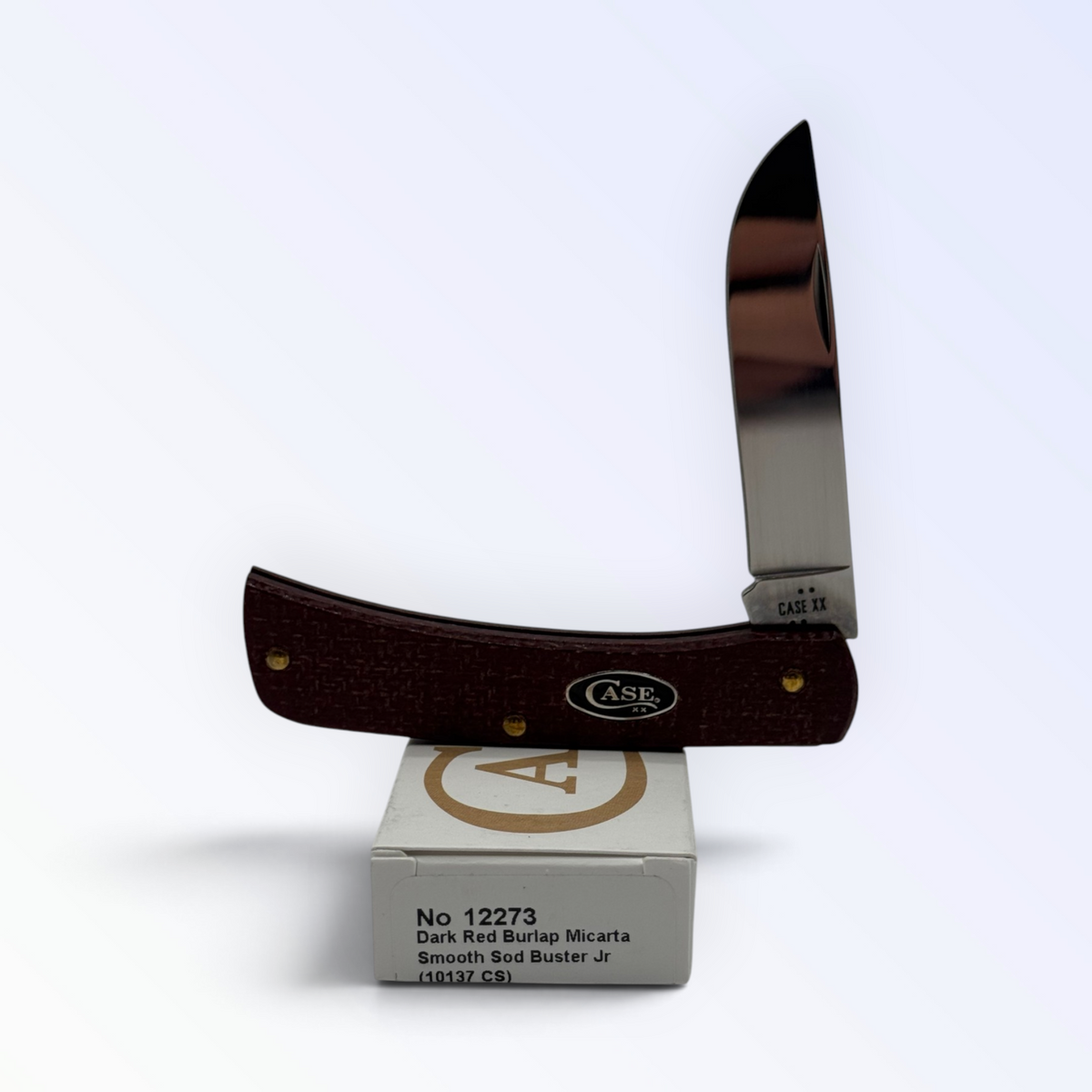 Case XX Sod Buster Jr with dark red burlap Micarta and 1095 carbon steel skinner blade, SKU 12273 — blades open resting on the factory box