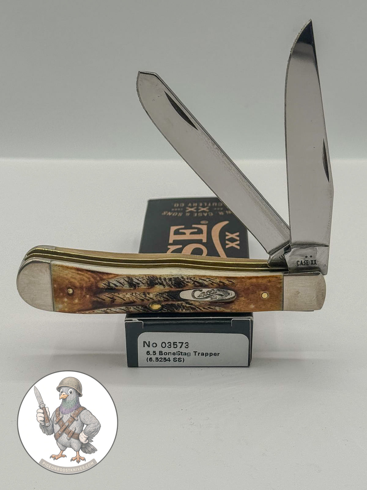 Case XX 6.5 BoneStag Trapper with BoneStag handles and large trapper pattern, SKU 03573 — blades open resting on the factory box