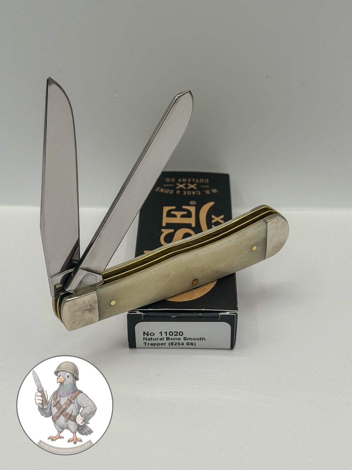 Trapper by Case XX in smooth natural bone with brass shield (11020), open on box with end label facing forward