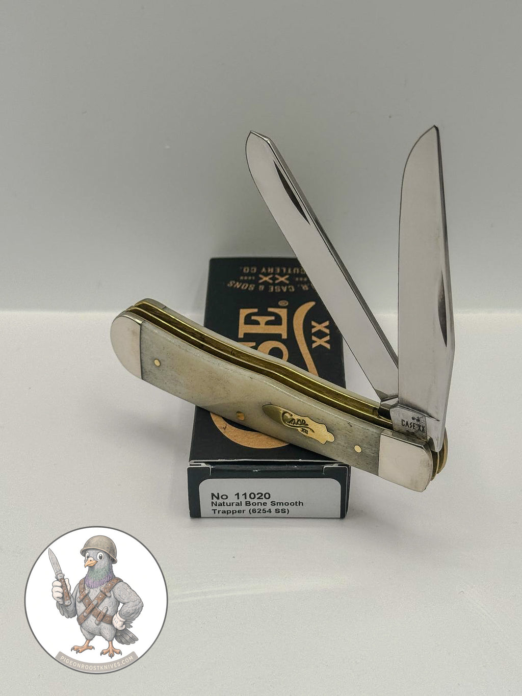 Case XX Trapper 11020: smooth natural bone with brass shield, studio shot open atop the retail box