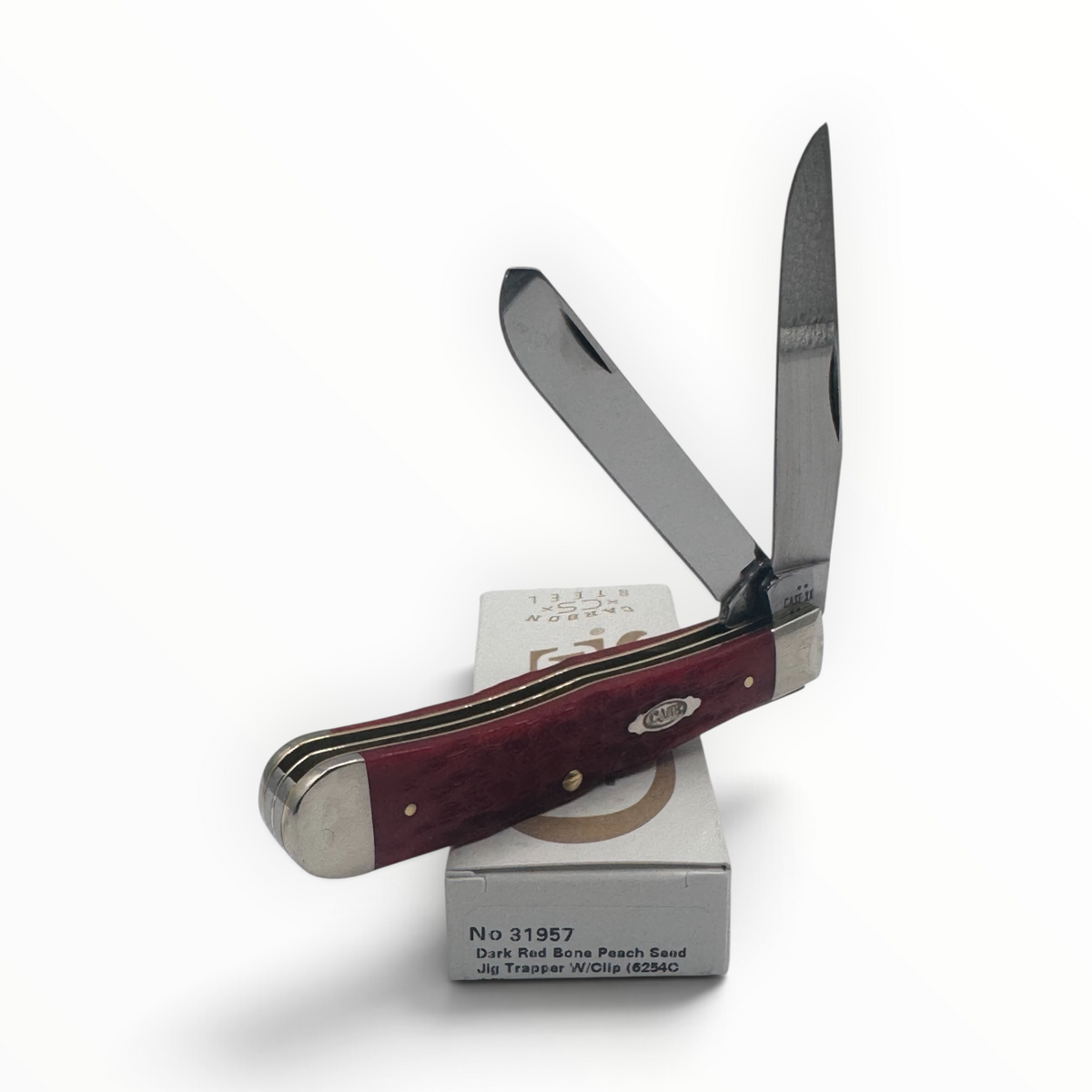 Pigeon Roost Knives Case XX Trapper pocket knife with dark red peach seed jigged bone handles and carbon steel blades.