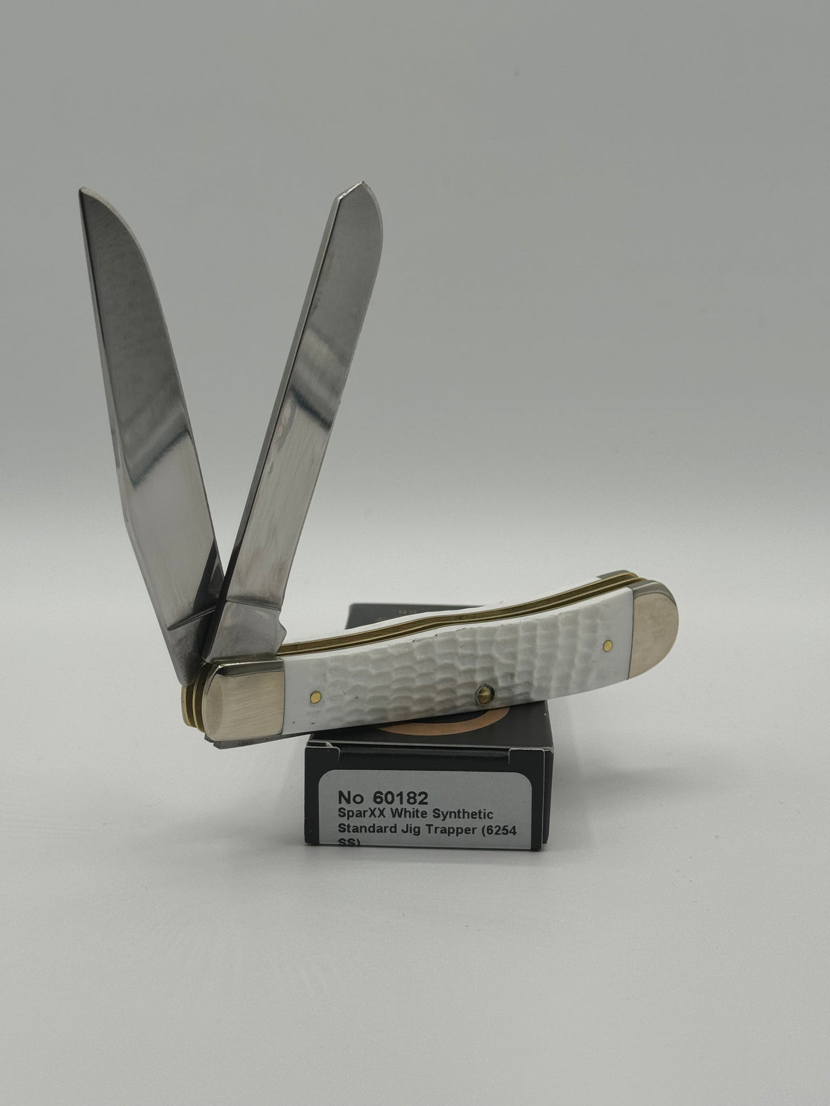 Pigeon Roost Knives Case XX SparXX Trapper pocket knife with white jigged synthetic handle and two stainless blades.
