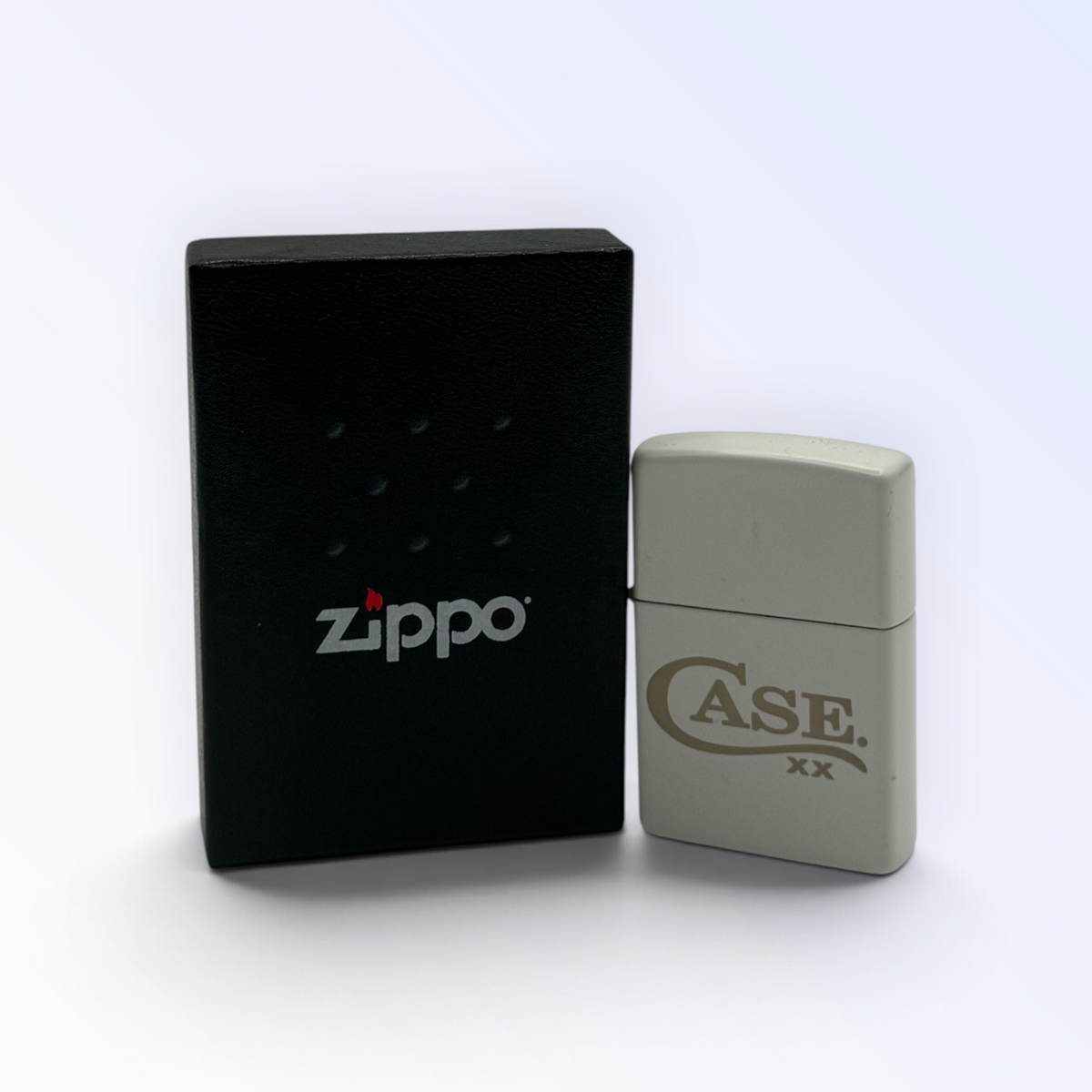 Pigeon Roost Knives white matte Zippo windproof lighter with gold Case XX logo next to a black Zippo gift box